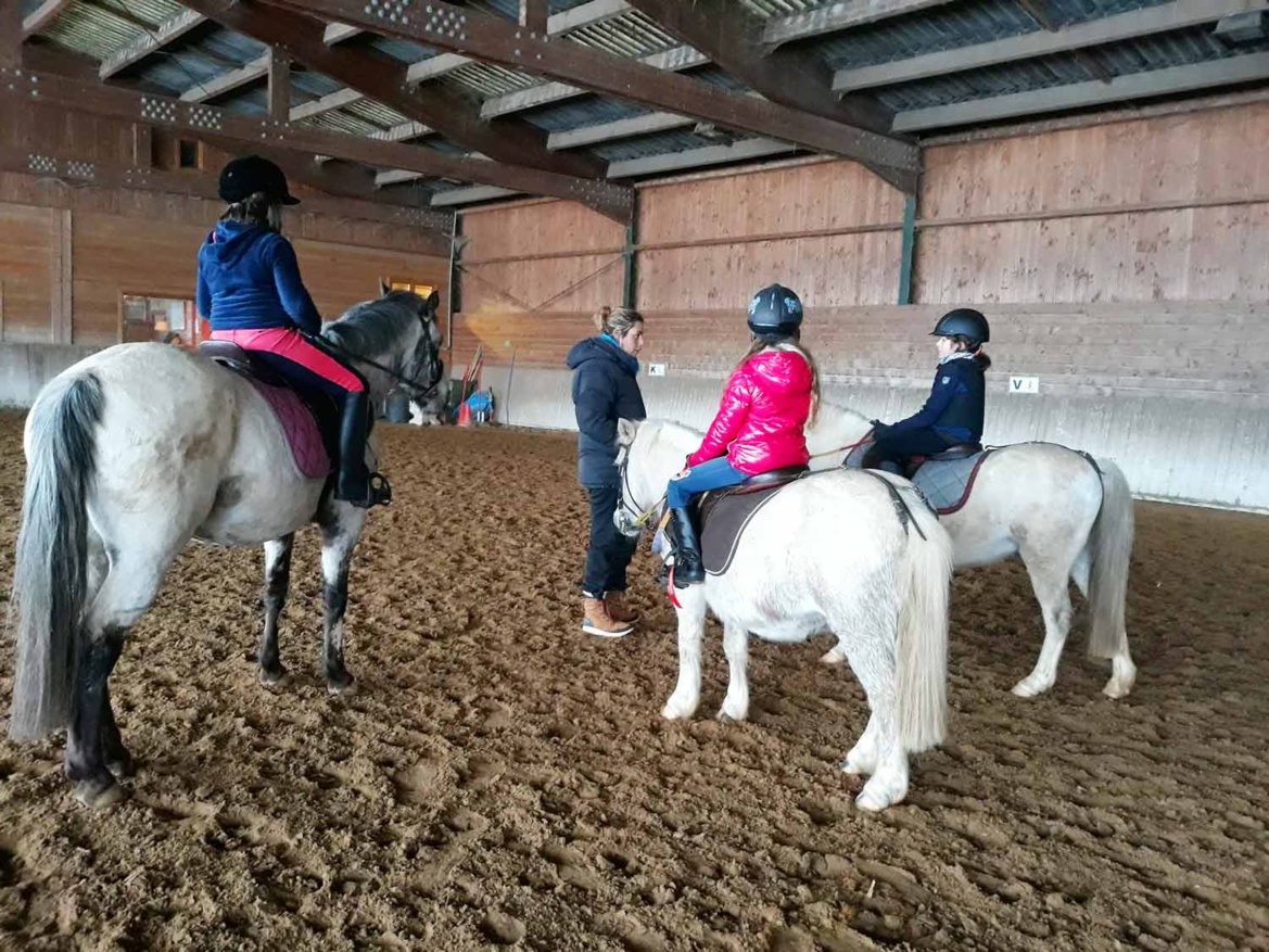 Les débutants en selle pour leur cours d'équitation aux Écuries du Rosey